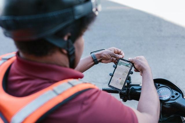 a person adjusting his phone, which is hooked up to his bike's handlebars